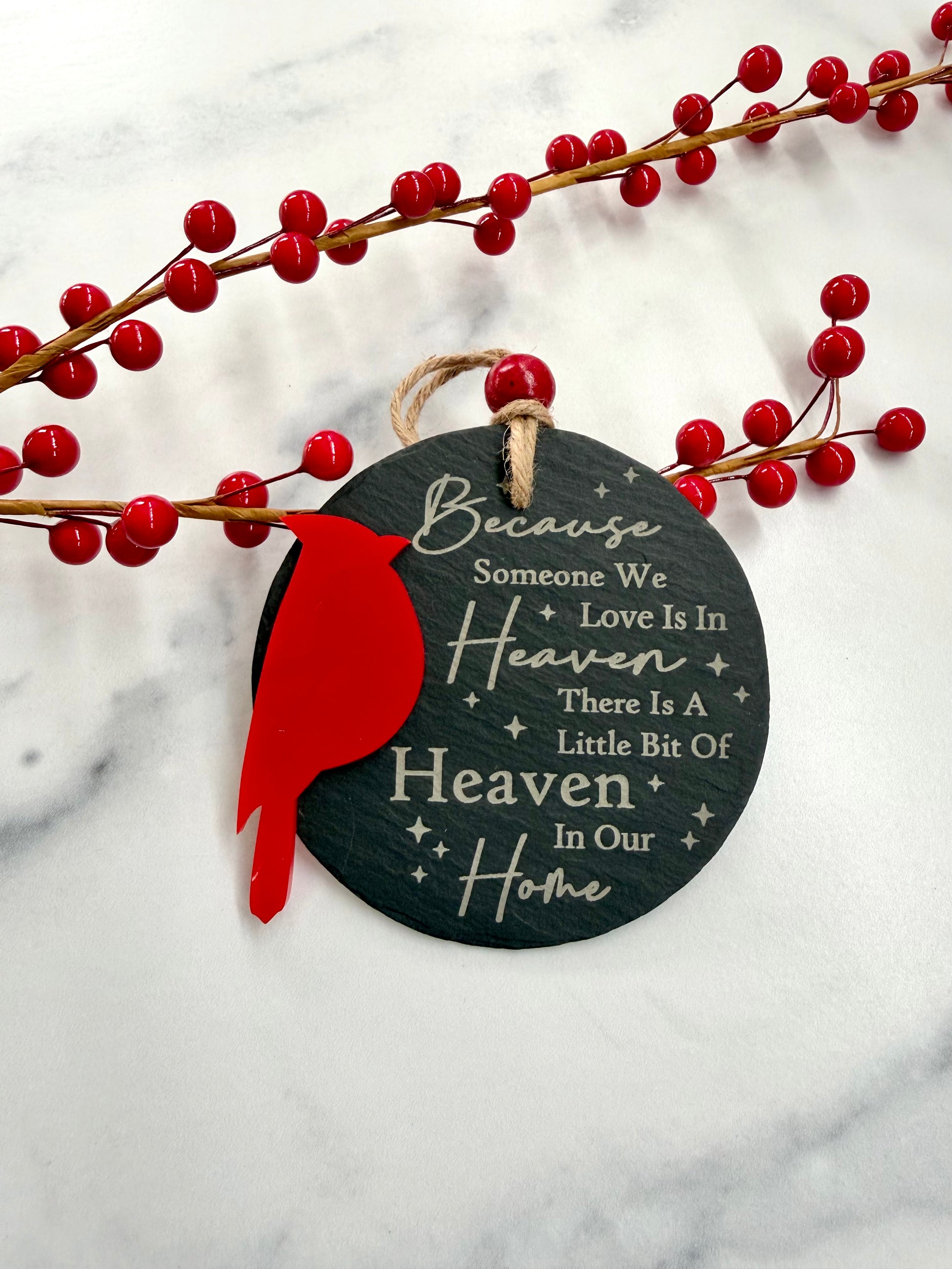 Decorative slate ornament with red bird and text on a marble background