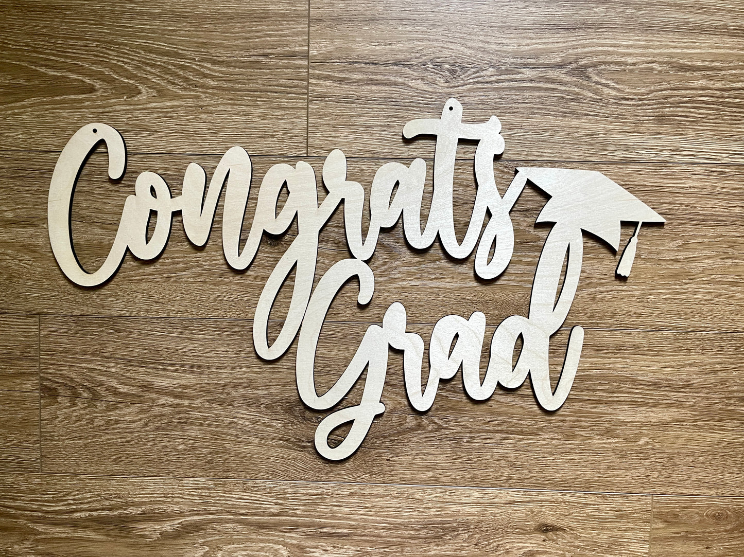 One piece Congrats Grad sign on wooden background.