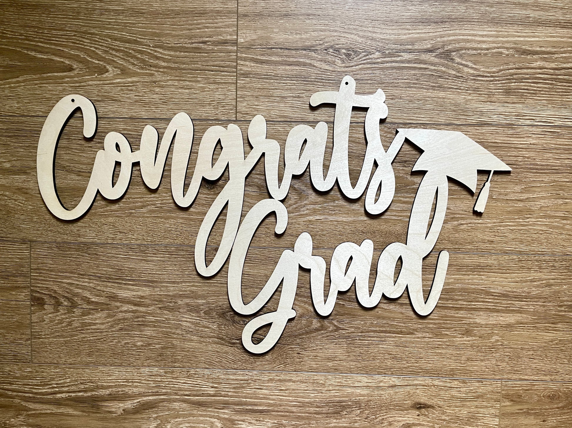 One piece Congrats Grad sign on wooden background.