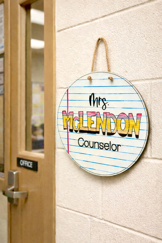 Circular sign with 'Mrs. McLendon Counselor next to an office door