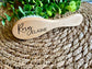 Wooden brush with 'Rory Elaine' engraving on a woven mat with greenery