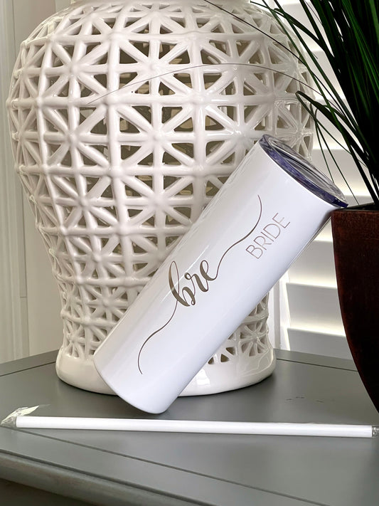 A white 20 oz. tumbler with the bride's name on it. There Is also a matching white straw.