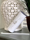 A white 20 oz. tumbler with the bride's name on it. There Is also a matching white straw.